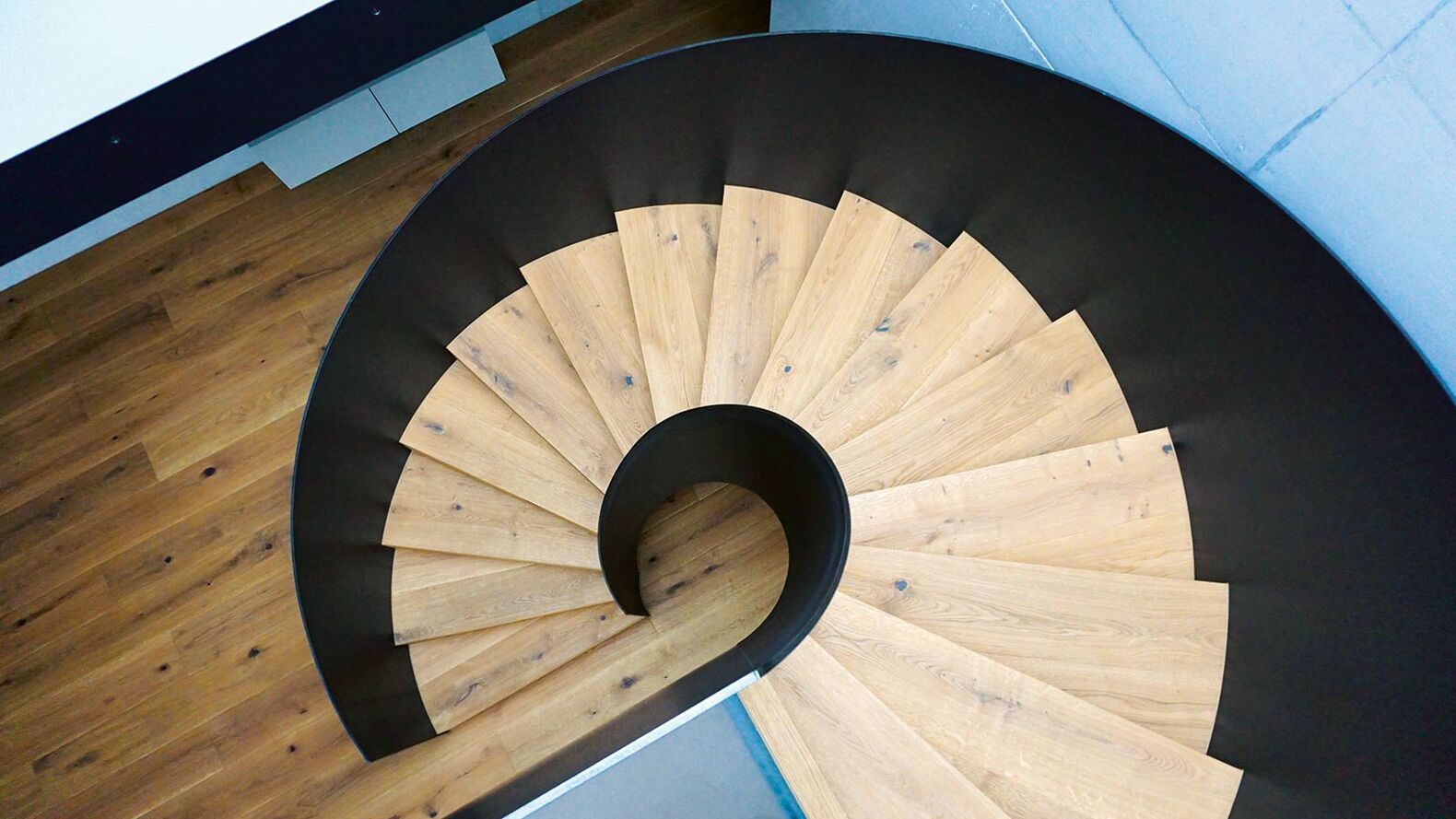 Elegant streckt sie sich vom Boden in die Höhe: Die aus rohem Stahl gefertigte und geölte «Wendeltreppe 42» von der Gyger Metallbau AG könnte gerade so gut ein Kunstwerk sein. Mit ihrem grosszügigen Treppenloch und dem Glaspodest flutet sie den Raum zudem mit viel natürlichem Licht. www.gygertreppen.ch