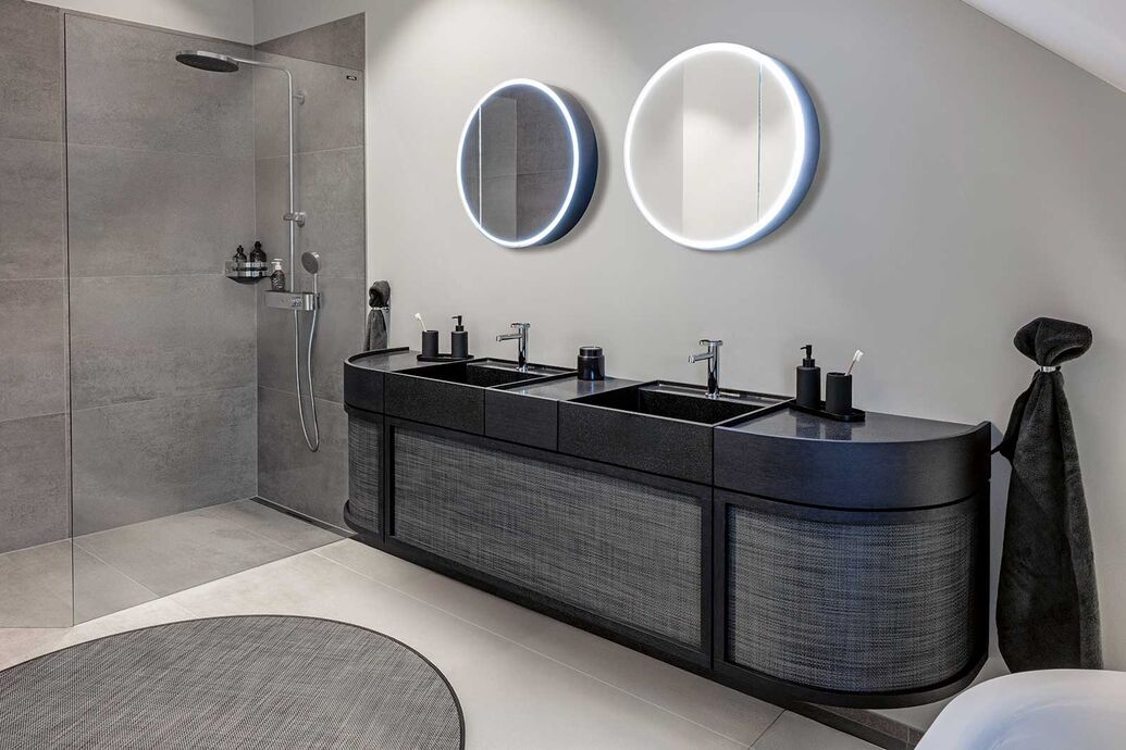 Nacher: Die grossen Platten am Boden und in der Dusche schaffen harmonische Strukturen. Eine begehbare Walk-In-Dusche schafft ein weites Raumgefühl.