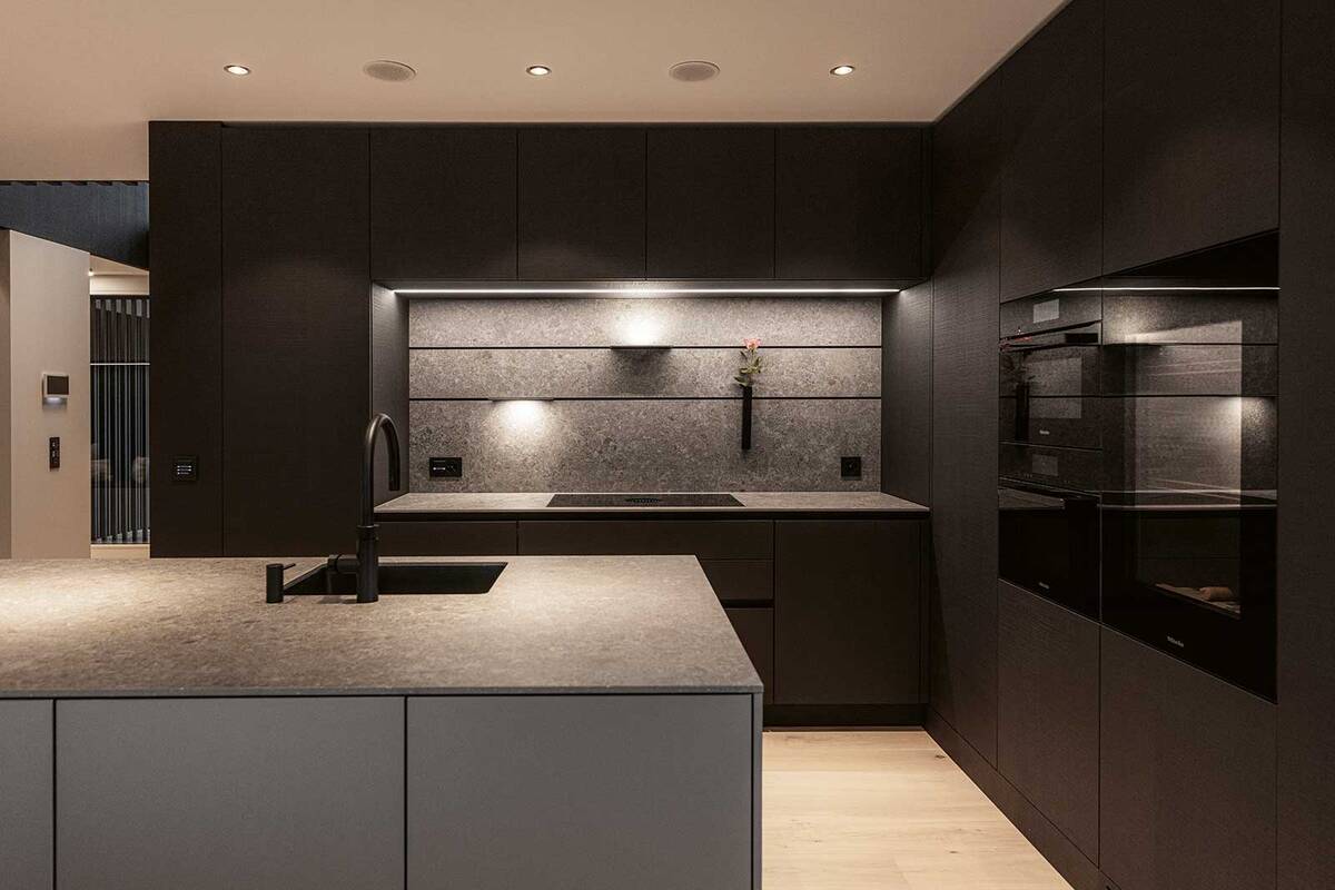 Die Küchenabdeckung und Rückwand aus Keramik in der Farbe «Inalco Meteora» erinnern an eine felsige und eisenhaltige Oberfläche und setzen stimmungsvolle Akzente beim Kochen. Orea AG.